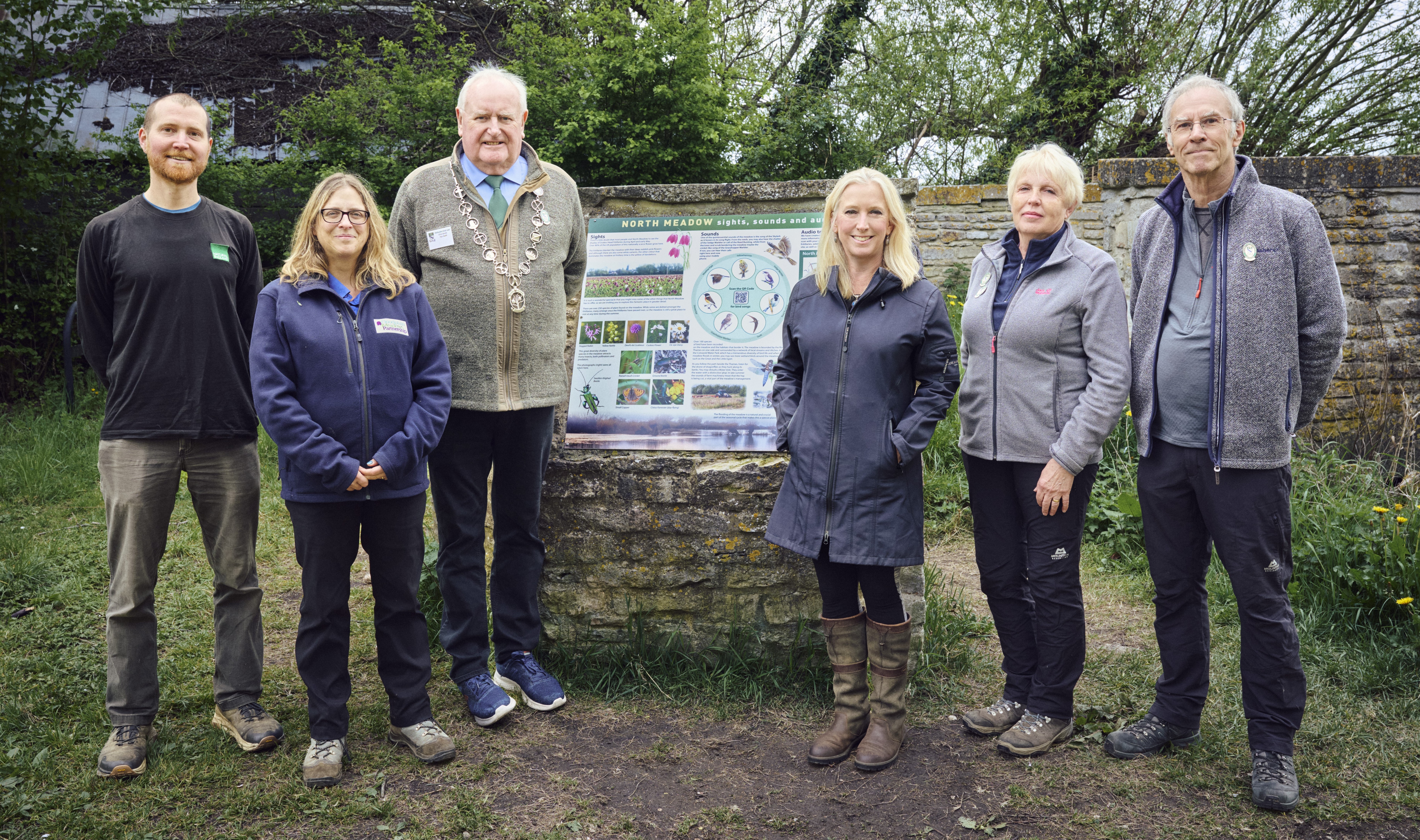 Six people standing in front of an interpretation board for the North Meadow NNR