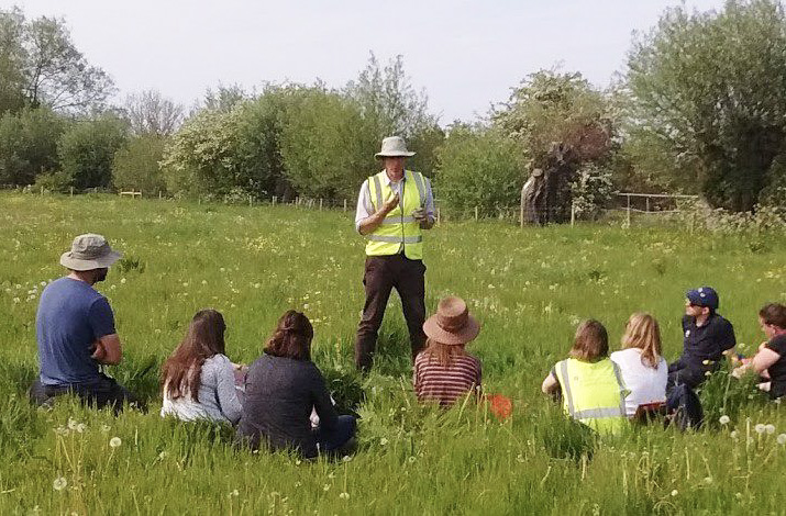 Image of researcher instructing people in a field