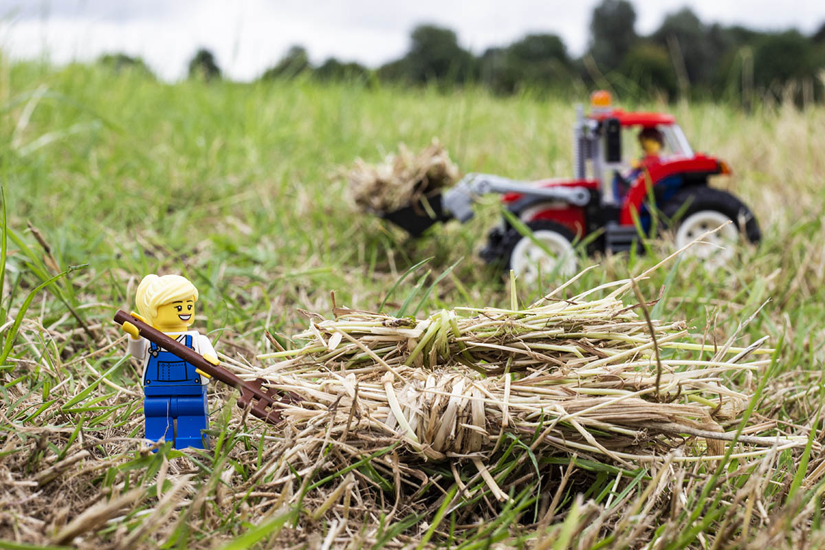 Photo of lego figures making hay with a tractor in a field